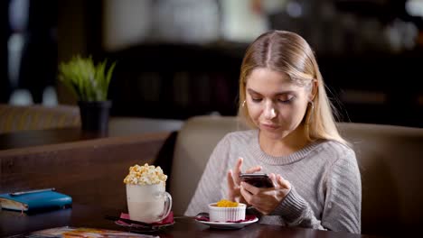 cute-young-girl-is-having-a-break-in-a-cafe