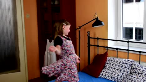 Cute-little-girl-dances-on-a-bed.-SLow-motion.-Childhood-concept