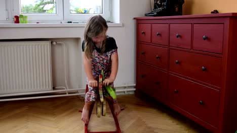 Cute-little-girl-dances-and-jumps-on-a-bed.-Small-girl-wears-flowered-dress.-Childhood-concept