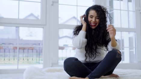 Laughing-brunette-with-red-lips-enjoys-music-in-headphones