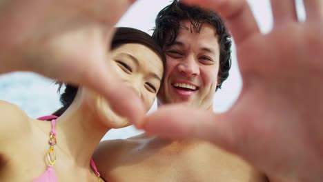 Ethnic-couple-heart-shape-hands-messaging-family-friends