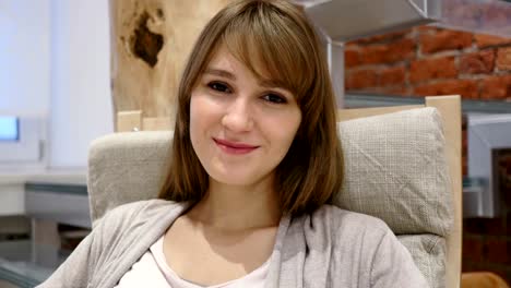 Portrait-of-Smiling-Young-Woman-Sitting-on-Relaxing-Chair