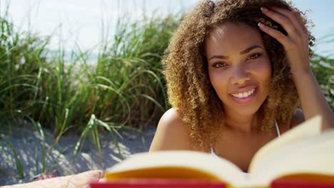 Portrait-of-Ethnic-female-on-cushions-reading-book