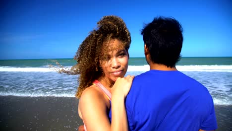 Portrait-of-multi-ethnic-couple-relaxing-on-beach