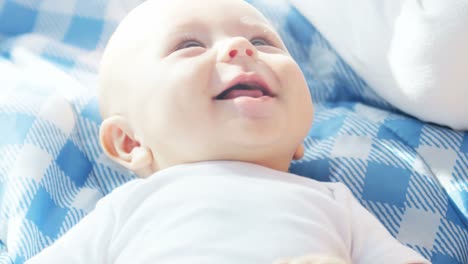 Portrait-of-Caucasian-baby-girl-lying-on-blanket