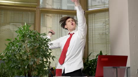 Young-man-in-a-suit-dances-in-the-office,-makes-funny-faces,-fools-around,-rejoices.-Work-in-the-office-concept-60-fps