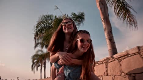 Teenage-girls-having-fun-with-piggyback-ride-on-summer-vacations