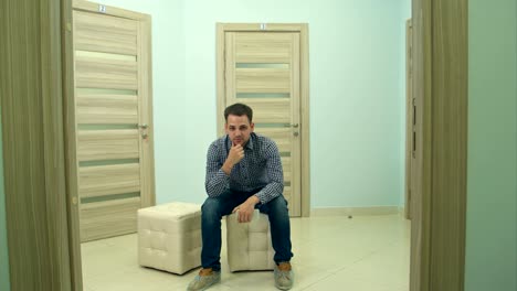 Male-patient-waiting-for-doctor's-appointment-nodding-his-head-and-looking-into-the-camera