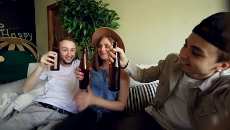 Punto-de-vista-toma-de-amigos-alegres-tomando-selfie-con-botellas-de-cerveza,-posando-y-sonriendo,-riendo-y-gesticulando.-Amistad-y-gente-joven-feliz-concepto.