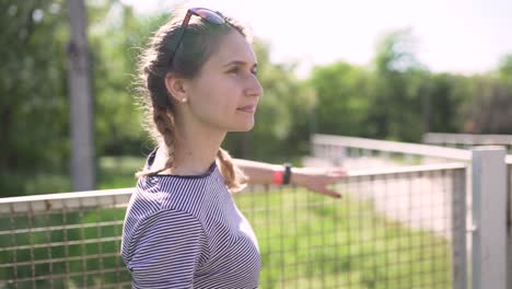 Porträt-einer-attraktiven-lächelnd-kaukasischen-Frau-in-einem-Park-mit-Brille