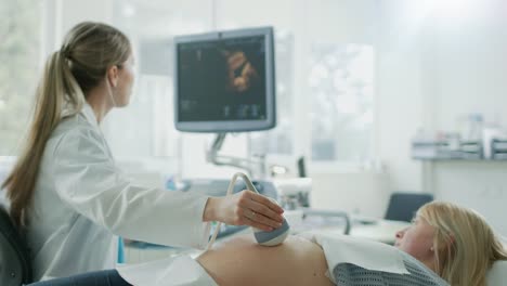 In-the-Hospital,-Obstetrician-Uses-Transducer-for-Ultrasound/-Sonogram-Screening-/-Scanning-Belly-of-the-Pregnant-Woman.-Computer-Screen-Shows-3D-Image-of-the-Healthy-Forming-Baby.