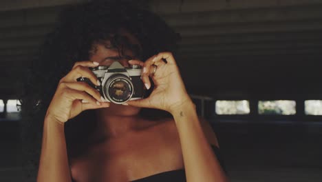 Beautiful-young-woman-shooting-photos-with-film-camera-in-urban-downtown-setting