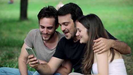 Amigos-se-centró-en-buscar-en-smartphone-en-el-parque-de-la-felicidad,-alegría,-relajación