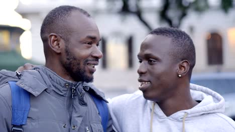 Two-young-black-african-friends-talking-and-smiling-in-the-street