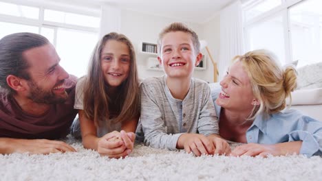 Porträt-der-Familie-liegen-auf-Teppich-In-Lounge-im-Hause-Schuss-In-Zeitlupe