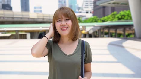 Attractive-young-smiling-Asian-woman-outdoors-portrait-in-the-city-real-people-series.-Outdoors-lifestyle-fashion-portrait-of-happy-smiling-Asian-girl.-Summer-outdoor-happiness-portrait-concept.