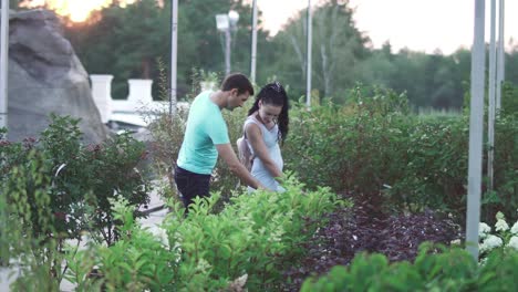 Adult-man-and-woman-walk-at-the-garden-and-talk