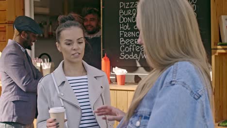 Smiling-woman-talking-to-her-friend-near-coffee-shop