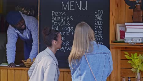 Zwei-Mädchen,-die-Wahl-snack-von-Speisekarte-Stand