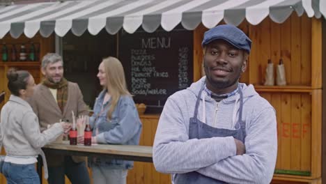 Portrait-of-owner-small-business-near-his-food-booth