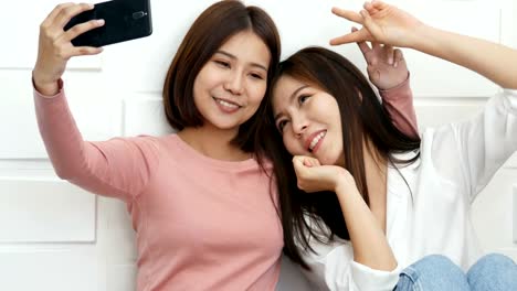 Beautiful-couple-women-selfie-together-with-attractive-smiling.-Asian-women-using-camera-in-smartphone-for-selfie-together.