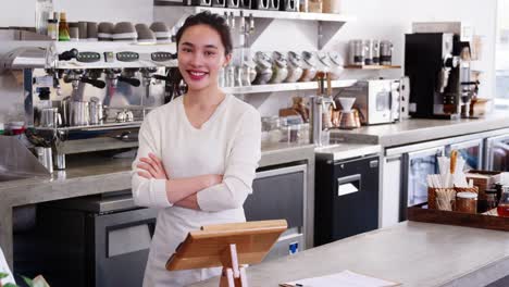 Dueño-de-la-cafetería-mujer-joven-detrás-de-contador,-cruzando-los-brazos