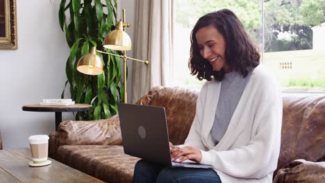 Young-mixed-race-woman-using-laptop-in-a-coffee-shop