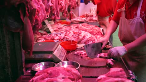 Metzger,-Zerkleinern-von-rohem-Fleisch-am-Fleischmarkt-in-Hong-Kong