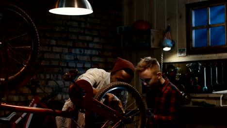 Man-teaches-a-boy-bicycle-maintenance