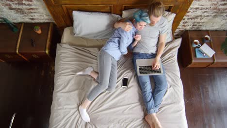 Woman-Joining-Boyfriend-Working-from-Bed