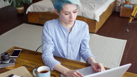 Weibliche-Freiberufler-arbeiten-am-Laptop-in-Loft-Wohnung