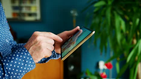 Businessman-Swiping-Through-Digital-Tablet-At-Home-Office