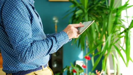 Businessman-Swiping-Through-Digital-Tablet-At-Home-Office