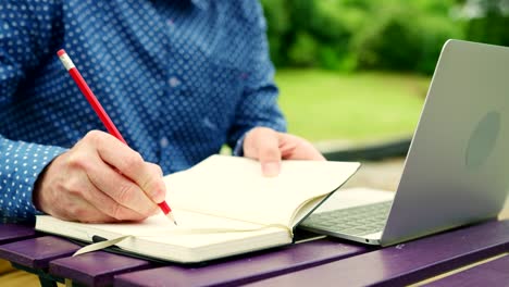 Casual-Businessman-Working-At-A-Table-Outdoors