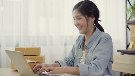 Beautiful-smart-Asian-young-entrepreneur-business-woman-owner-of-SME-online-checking-product-on-stock-and-save-to-computer-working-at-home.-Small-business-owner-at-home-office-concept.