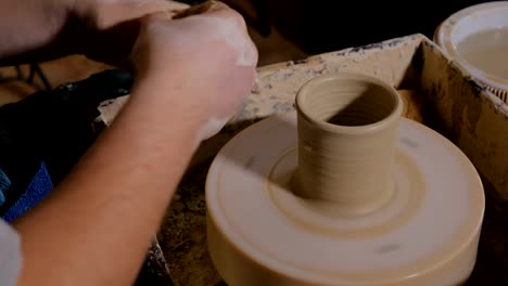 Professional-male-potter-working-in-workshop