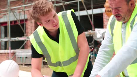 Builder-auf-Baustelle-diskutieren-Arbeit-mit-Apprentice