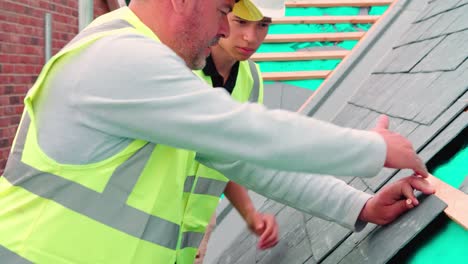 Construction-Worker-With-Apprentice-Laying-Slate-Tiles