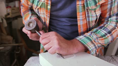 Stone-Mason-bei-der-Arbeit-auf-Skulptur-In-Studioaufnahme-mit-roten-Kamera