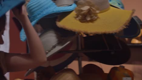 Two-young-women-trying-on-hats-in-a-store