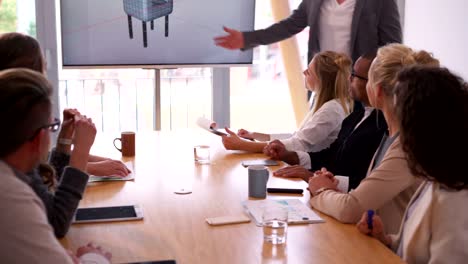 Multi-ethnic-business-team-members-attending-presentation-in-meeting-room