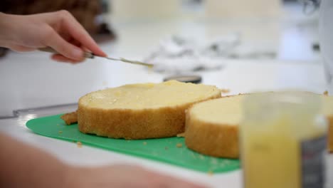 Close-Up-Of-Woman-In-Bakery-Spreading-Icing-On-Cake