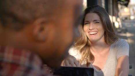 Mixed-race-couple-relaxing-at-a-table-outside-a-coffee-shop