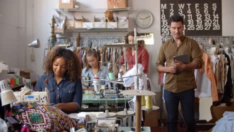 Colegas-hablando-en-un-taller-de-fabricación-de-ropa