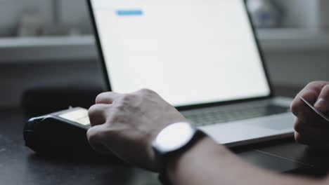 Woman-uses-credit-card-terminal-in-office.