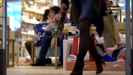 Concepto-de-compras-familiares.-Marido-aburrido-esperando-la-esposa-mientras-que-ella-elige-zapatos-de-la-colección-de-verano