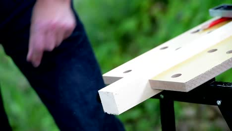 Carpintero-aserrando-una-plaza-de-madera-con-una-sierra-de-madera