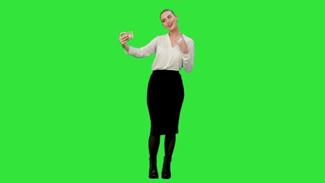 Junge-hübsche-Geschäftsfrau-nehmen-Selfie-mit-Handy-auf-einem-Green-Screen,-Chroma-Key