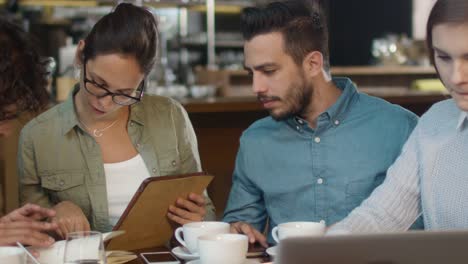 Small-Creative-Team-of-Active-Young-People-Having-Meeting-and-Discussion-in-Coffee-Shop.