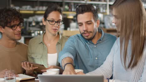 Small-Creative-Team-of-Active-Young-People-Having-Meeting-and-Discussion-in-Coffee-Shop.